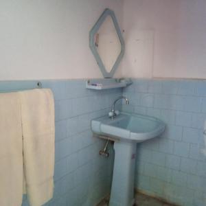 baño con lavabo y espejo en la pared en Foreigner Tourist Inn, en Tīsh