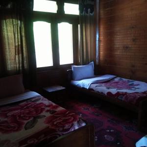 Foreigner Tourist Inn في Tīsh: غرفة بسريرين ونوافذ