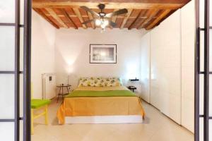 een slaapkamer met een bed en een plafondventilator bij Casa Amorino in Lucca