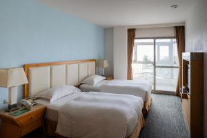 A bed or beds in a room at Ocean Hotel Hualien
