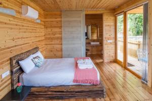 a log cabin bedroom with a bed and a balcony at Cabanas de Canduas in Cabana de Bergantiños