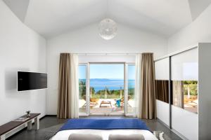 a bedroom with a bed and a view of the ocean at Luxury Panorama Vila with amazing Seaview in Gondolici 7 km from Rabac in Labin