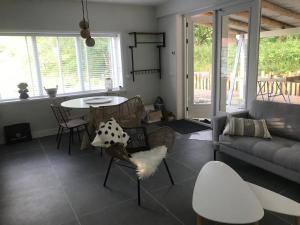 ein Wohnzimmer mit einem Sofa, einem Tisch und Stühlen in der Unterkunft Vakantiehuis Zilt in Ouddorp