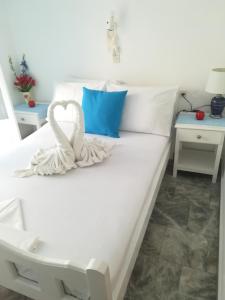 a white bed with a white swan on it at Massouri Rooms in Masouri