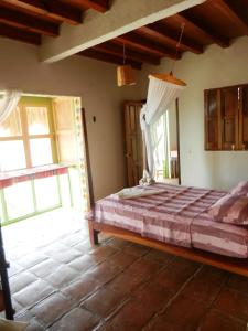 a bedroom with a bed in a room with windows at Altamira Mazunte in Mazunte