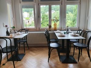 a dining room with tables and chairs and windows at Boutique Hotel Villa Horbach in Idar-Oberstein