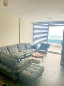 ein Wohnzimmer mit einem Sofa, Stühlen und einem Tisch in der Unterkunft Luxury Penthouse Shkembi Kavajes in Durrës