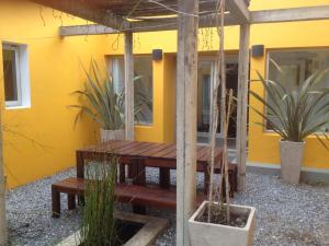 einem Picknicktisch aus Holz vor einem gelben Haus in der Unterkunft Casa Mar in Punta del Este
