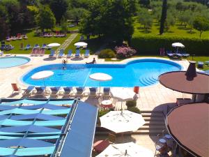 a large swimming pool with umbrellas and chairs at Parc Hotel Casa Mia in Lazise