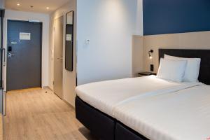 a bedroom with a large bed with a blue wall at Hotel Matts in Espoo