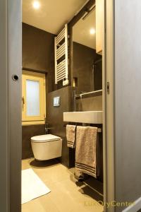 a bathroom with a white toilet and a sink at LuxOry Center - Brescia centro in Brescia