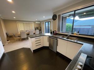a kitchen with a sink and a large window at Your Happy place-Quiet area & Spa pool in Rotorua