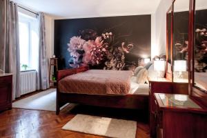 a bedroom with a bed and a wall with flowers at Apartma Ajda in Železniki