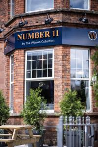 um edifício com um cartaz que lê o número e uma mesa de piquenique em Number 11 by the Warren Collection em Belfast