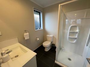 a bathroom with a toilet and a sink and a shower at Your Happy place-Quiet area & Spa pool in Rotorua +13 photos