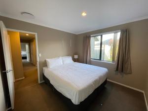 a bedroom with a large bed and a window at Your Happy place-Quiet area & Spa pool in Rotorua