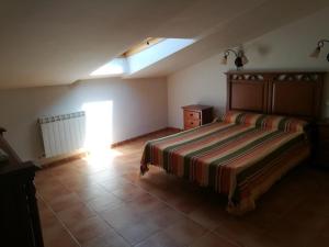ein Schlafzimmer mit einem Bett in einem Zimmer mit einem Fenster in der Unterkunft Casa Rural Valdecorneja in Hoyorredondo