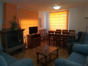 ein Wohnzimmer mit Kamin, Tisch und Stühlen in der Unterkunft Casa Rural Valdecorneja in Hoyorredondo