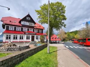 a building with a red roof on the side of a street at Stokrotka Natura Tour in Karpacz