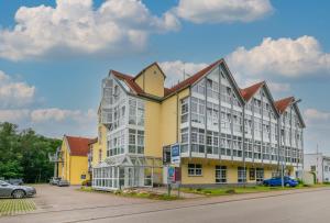 a large yellow and white building with a parking lot at G&G Boardinghouse in Aalen