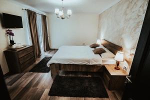 Schlafzimmer mit einem Bett und einem Kronleuchter in der Unterkunft Pensiunea Romana in Onești