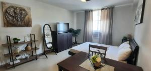 a living room with a bed and a table at Cozy Studio near Beaches with NetFlix and Pool in Mactan