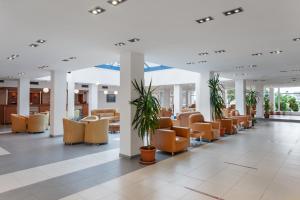 una zona de espera en un hospital con sillas naranjas en Hotel Sirena, en Saturn