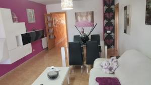 a living room with a white couch and purple walls at Apartamento LAUMA in Benalúa de Guadix