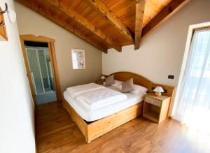 een slaapkamer met een bed in een kamer met houten vloeren bij Garnì Canterbury in Castello Tesino