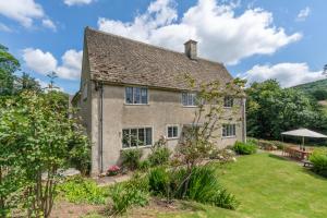 een oud huis met een tuin ervoor bij Court Cottage in Stroud