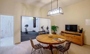 a dining room with a table and chairs and a television at Luxury Beachfront Villa Raquel with Private Pool & Gym at Šolta, Croatia in Nečujam