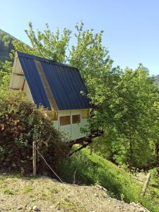 un granero con techo azul en una colina en Cabane dans un pommier, en Boutx