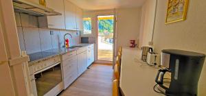 a kitchen with white cabinets and a refrigerator at Sonne Holiday Rooms in Unterseen