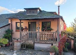 Casa pequeña con terraza de madera y porche en La Nogala Casa Rural en Labaniego