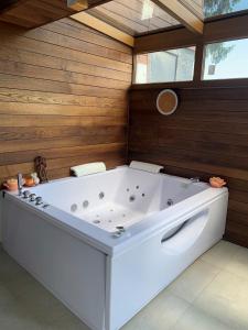 eine große weiße Badewanne in einem Zimmer mit Holzwänden in der Unterkunft Ferienhaus Jeschkenpanorama in Luftkurort Lückendorf