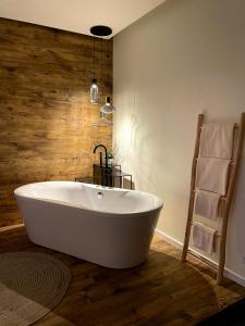 a bath tub in a bathroom with a wooden wall at Golden Key Apartments in Liberec