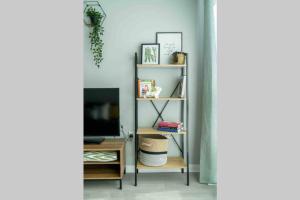 a room with a tv and a book shelf at Kew Gardens retreat in Kew Bridge