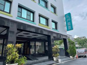 un edificio con una señal delante de él en Weifeng Boutique Business Hotel - Zhanqian Branch en Pingtung City