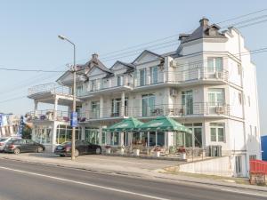 un grande edificio bianco sul lato di una strada di A klub apartmani a Mrčajevci