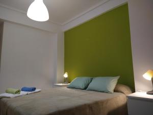 a bedroom with a green wall and a bed at PENSION132 in A Coruña
