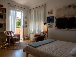1 Schlafzimmer mit einem Bett, 2 Stühlen und einem Fenster in der Unterkunft Cinque terre affittacamere Atelier ouvert! in La Spezia