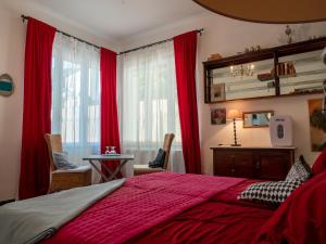 Schlafzimmer mit roten Vorhängen, einem Bett und einem Schreibtisch in der Unterkunft Cinque terre affittacamere Atelier ouvert! in La Spezia
