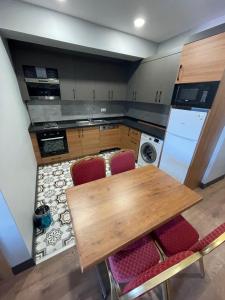 cocina con mesa de madera y sillas rojas en Almina Apartments&Suites en Estambul