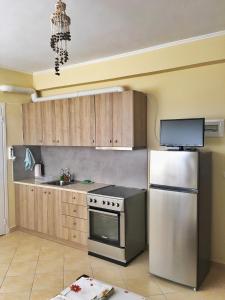 a kitchen with a stainless steel stove and a refrigerator at Vrachos Sunrise Apartment in Vrachos