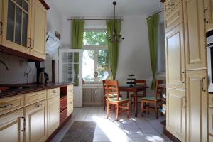 eine Küche mit einem Tisch und Stühlen sowie einem Fenster in der Unterkunft Gohliser Stadtwohnung in Leipzig