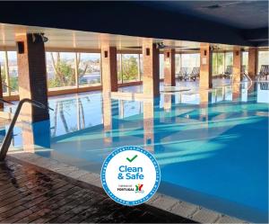 a large swimming pool with a sign in front of it at Santana Hotel & SPA in Vila do Conde