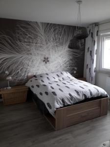 a bedroom with a bed and a wall with a flower mural at La chambre Plume in Truchtersheim