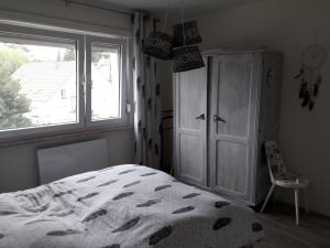 una camera con letto, finestra e sedia di La chambre Plume a Truchtersheim
