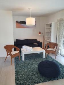 ein Wohnzimmer mit einem Sofa, einem Tisch und Stühlen in der Unterkunft Ferienhaus 2 Achterwasser-Findling Usedom in Lütow