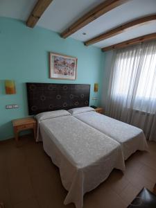 a bedroom with a large bed in a room with blue walls at Hotel Puerta de Cazorla in Cazorla